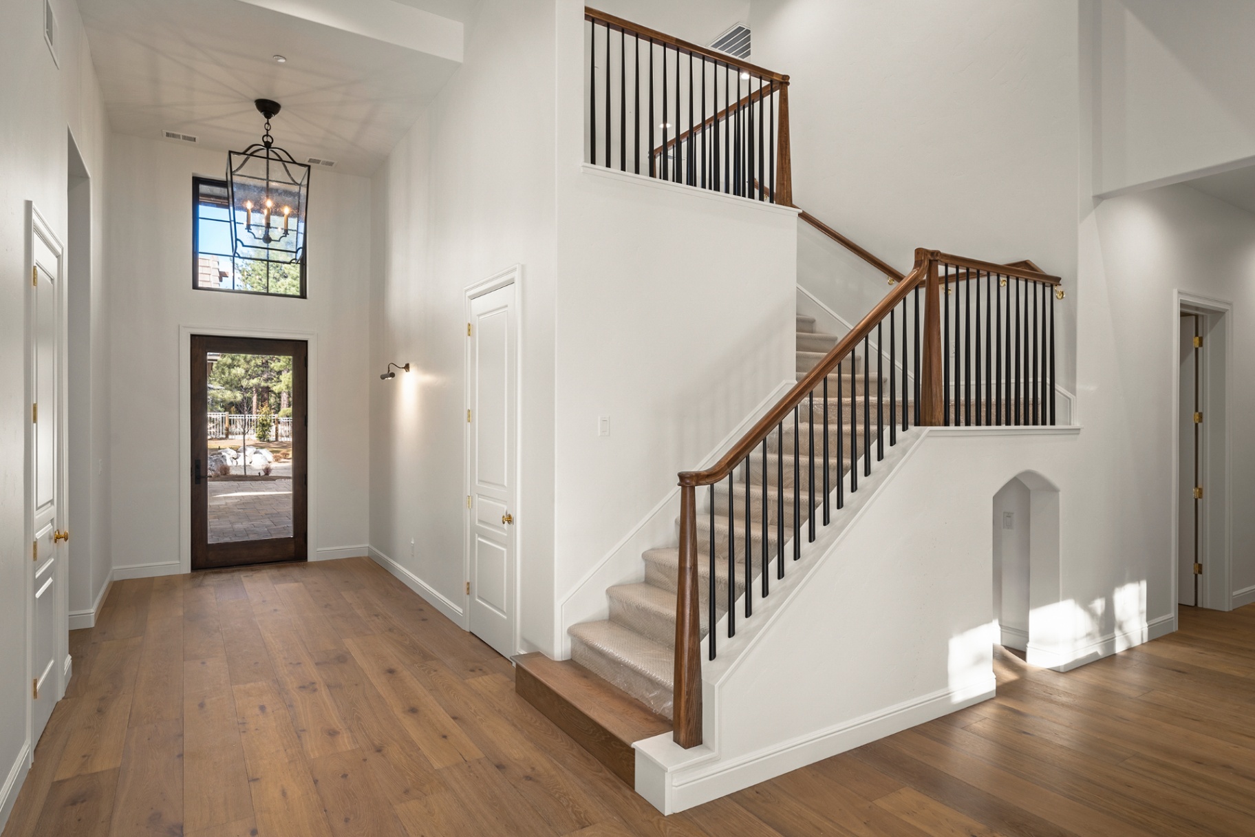 Two-story foyer with white oak floors and iron-and-wood staircase