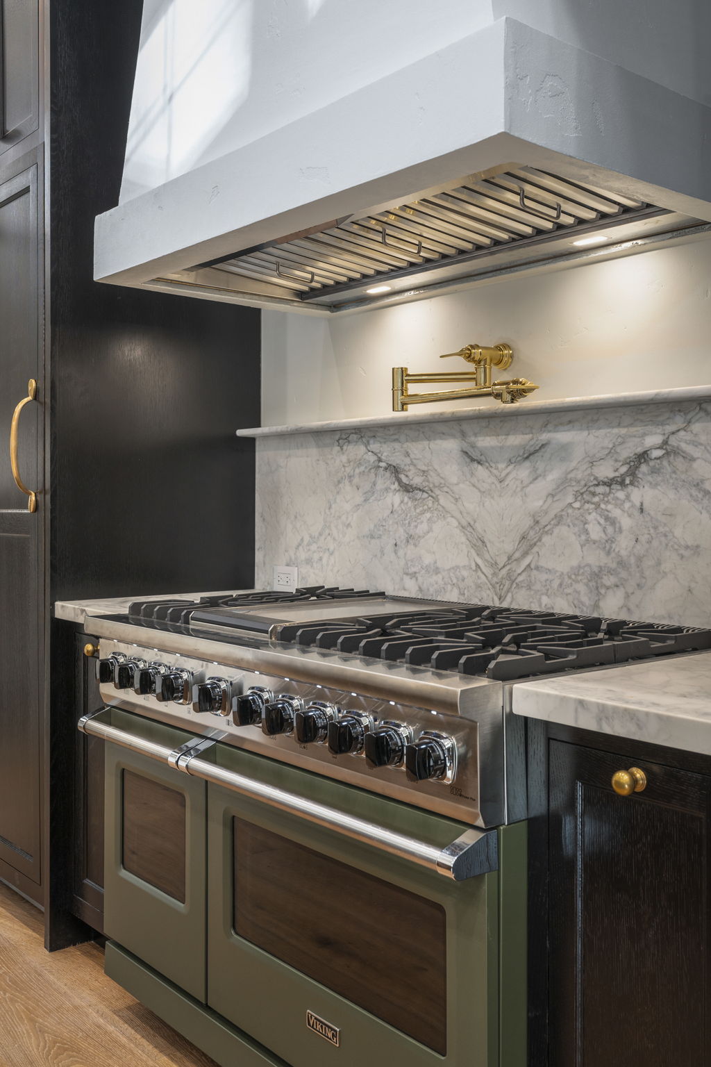 48-inch Viking range in sage green with honed marble backsplash and brass pot-filler