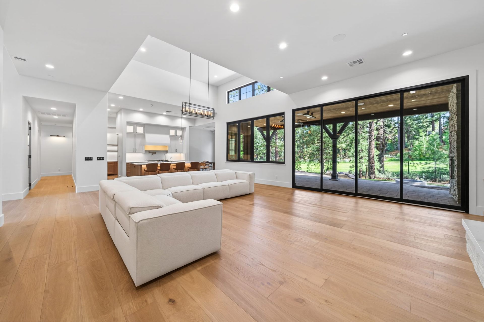 Great room with white oak floors and floor-to-ceiling glass
