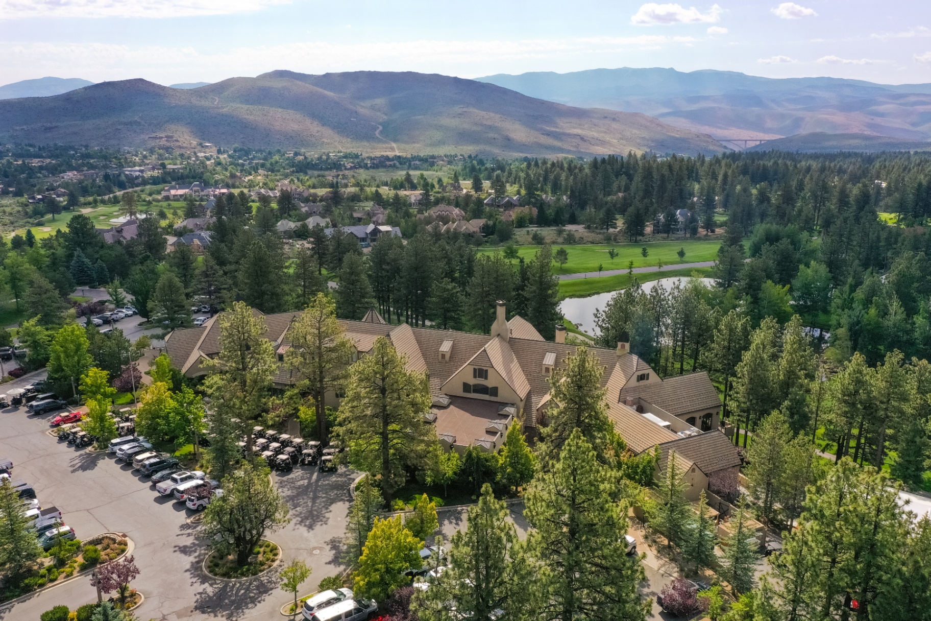 Aerial view of the Montreux clubhouse surrounded by pines with the valley and mountains beyond
