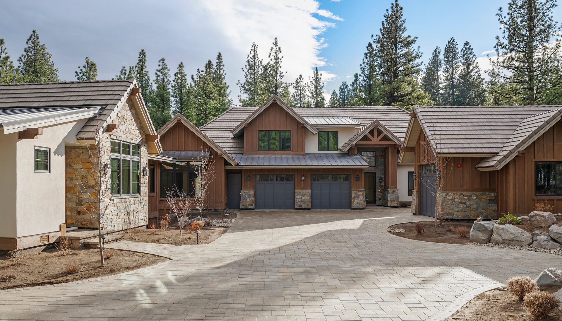 Front elevation with board-and-batten cedar, stone accents, and paver drive